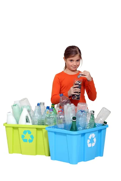 Młoda dziewczyna recyklingu butelek plastikowych i baterie — Zdjęcie stockowe