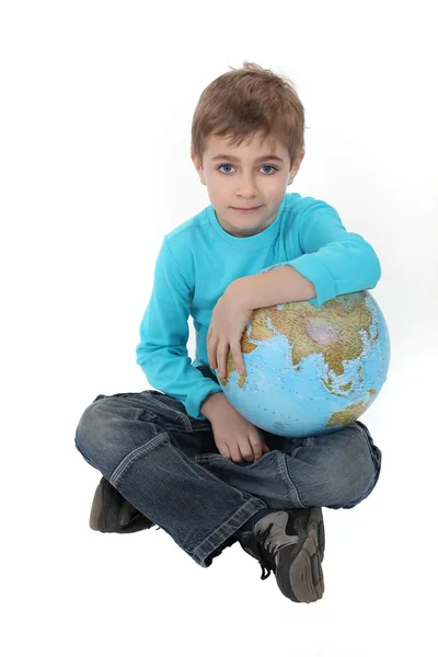 Блідий хлопчик з глобусом на колінах — стокове фото