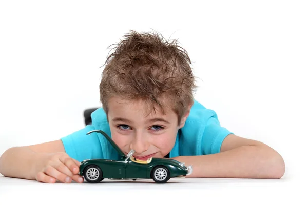 Giovane ragazzo giocare con un giocattolo auto — Foto Stock