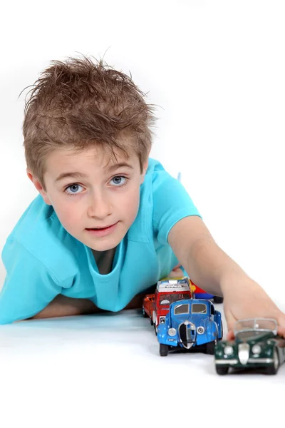 Mały chłopiec bawiący się zabawkowymi samochodami — Zdjęcie stockowe