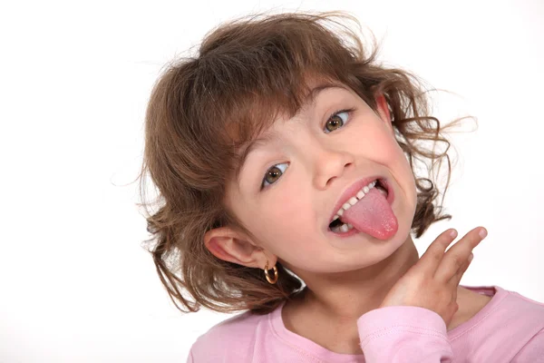 Маленькая девочка высовывает язык — стоковое фото
