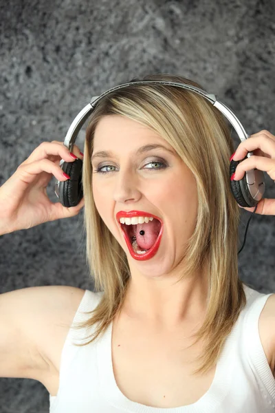 Ventilador de música loira com piercing na língua — Fotografia de Stock