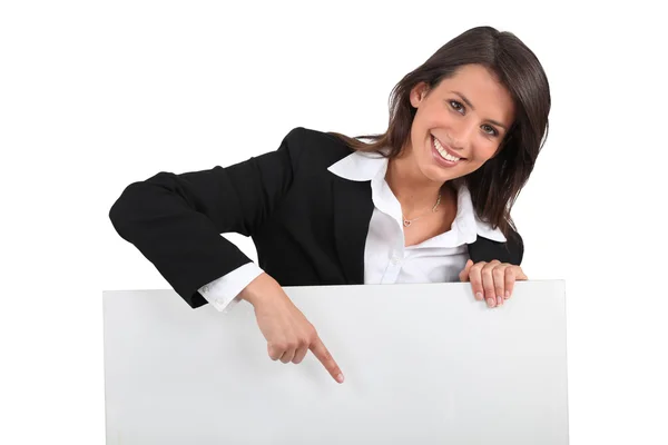 Geschäftsfrau zeigt auf Schild — Stockfoto