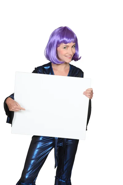 Frau in lila Perücke mit einem Brett, das für Ihre Nachricht leer gelassen wurde — Stockfoto