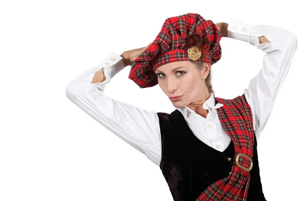 Kvinna klädd i traditionell skotsk outfit med händerna på huvudet — Stockfoto