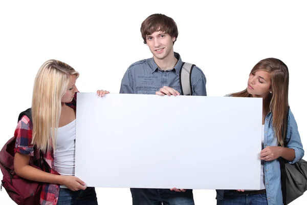 Drei Teenager halten Tafel in der Hand — Stockfoto