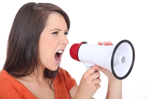Розлючена жінка кричить в акустичному телефоні — стокове фото