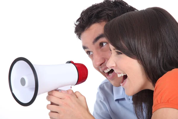 Giovane coppia urlando in un megafono — Foto Stock