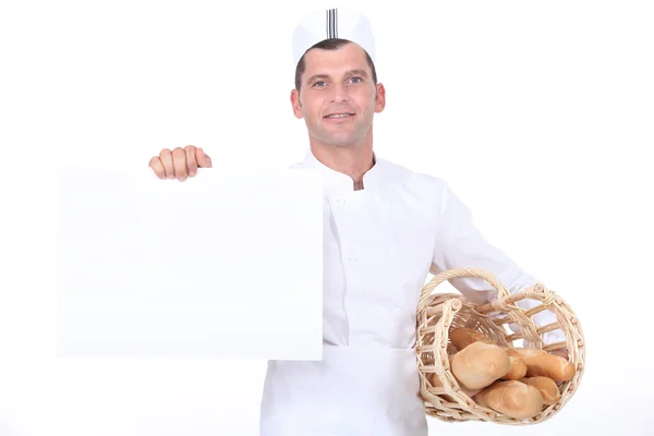 Un panadero sosteniendo un cartel blanco . —  Fotos de Stock