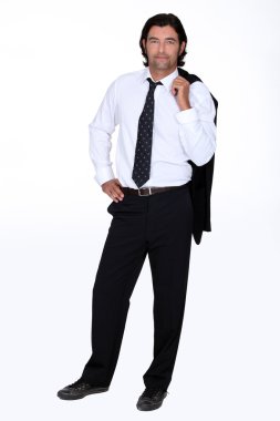 Studio shot of a man in a suit with his jacket slung over his shoulder clipart