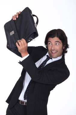 A business man is protecting his face with a briefcase, he looks amused clipart