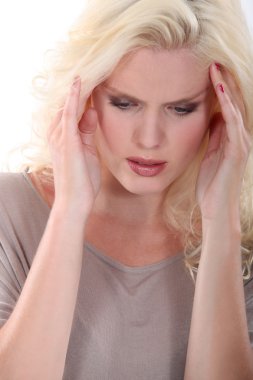 Blond woman suffering from head ache clipart