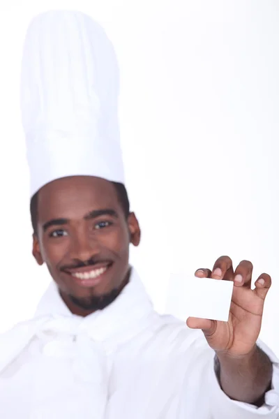Chef holding up his restaurant's business card — Stock Photo, Image