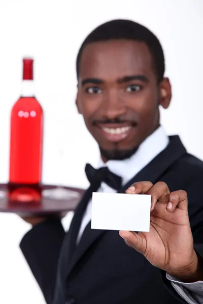 Vin servitör håller fram ett visitkort tomt för din information — Stockfoto