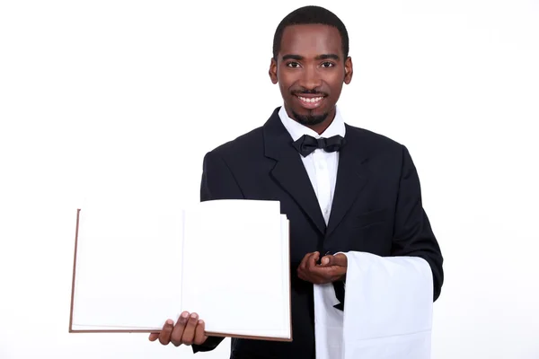 Чорний офіціант, що показує меню — стокове фото