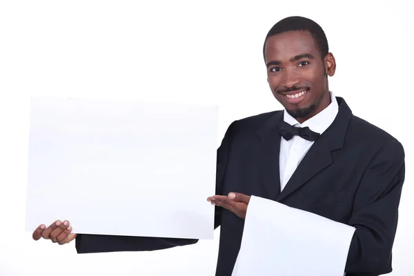 Studio shot of a waiter with a board left blank for your image — Stock Photo, Image