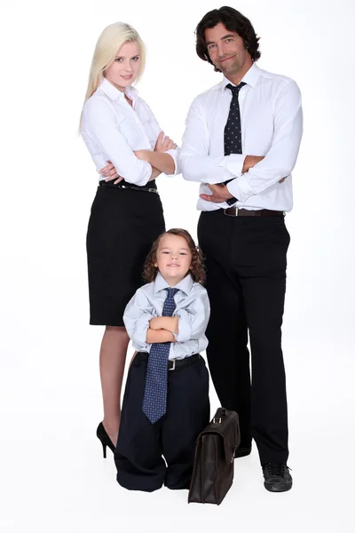 Hombre y mujer en traje inteligente y niño pequeño vestido como un hombre de negocios — Foto de Stock