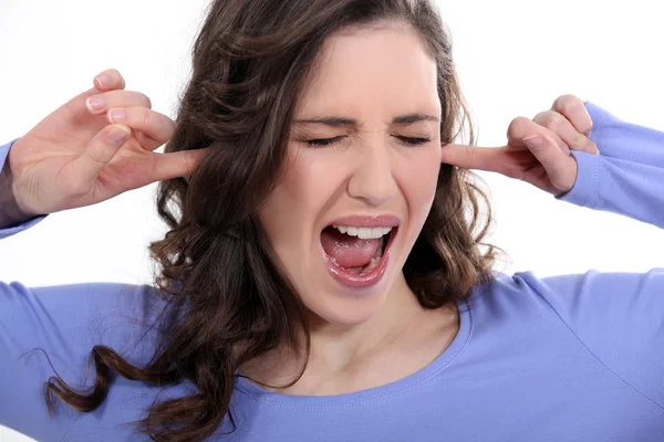 Vrouw met haar vingers in haar oren — Stockfoto