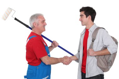 Experienced tradesman welcoming his new recruit clipart