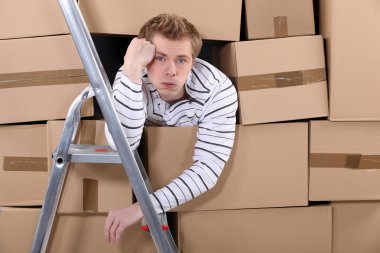 Man stuck behind stacks of cardboard boxes clipart