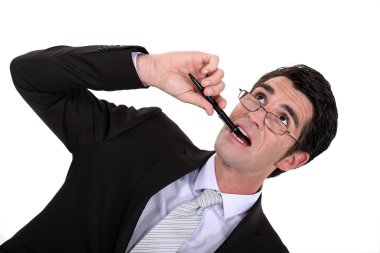 Businessman chewing his pen clipart