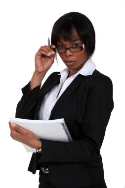 Serious businesswoman looking over her glasses clipart