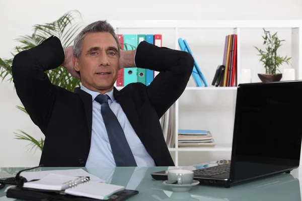 Geschäftsmann entspannt am Schreibtisch — Stockfoto