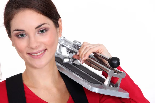 Woman holding tile cutting tool over shoulder — Stock Photo, Image