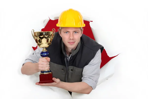A construction worker holding a trophy cup. — Stock Photo, Image