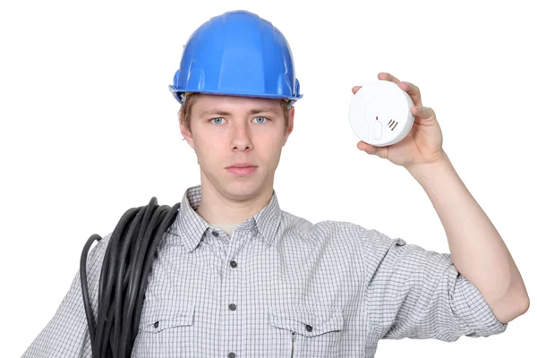 Young electrician holding smoke alarm — Stock Photo, Image