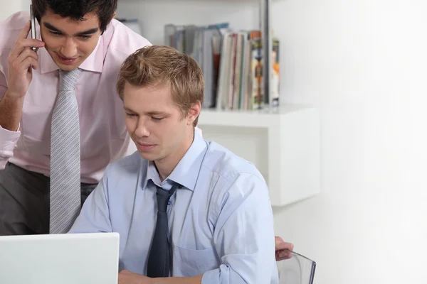 Unga affärsmän tittar på en bärbar dator — Stockfoto