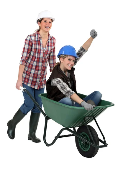 Two female construction workers with wheelbarrow — Stock Photo, Image