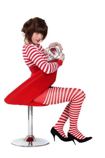 A cute brunette wearing red and white stripes and eating marshmallows. — Stock Photo, Image
