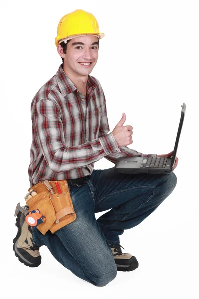 Construtor feliz com laptop dando o polegar para cima — Fotografia de Stock
