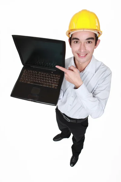 Νεαρός άνδρας σε ένα ειδικό κράνος με ένα φορητό υπολογιστή — Φωτογραφία Αρχείου