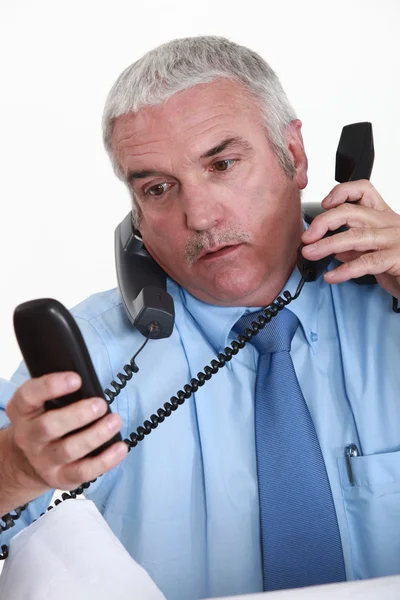 Oprimido trabalhador de colarinho branco respondendo telefones — Fotografia de Stock