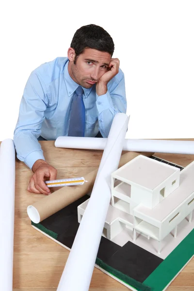 Nedstämd arkitekt sitter vid sitt skrivbord — Stockfoto