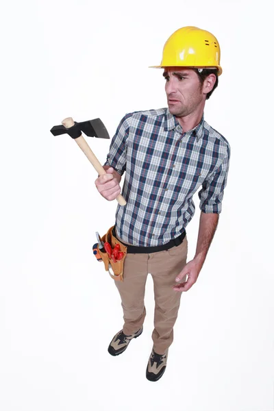 A handyman looking weirdly at his hatchet. — Stock Photo, Image