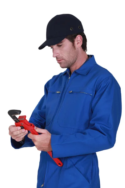 Tradesman che regola una chiave a tubo — Foto Stock