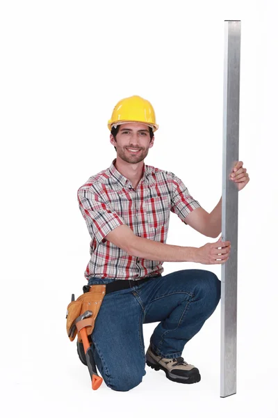 Construction worker crouching with metal — Stock Photo, Image