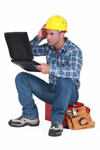 Construtor confuso sentou-se com laptop — Fotografia de Stock