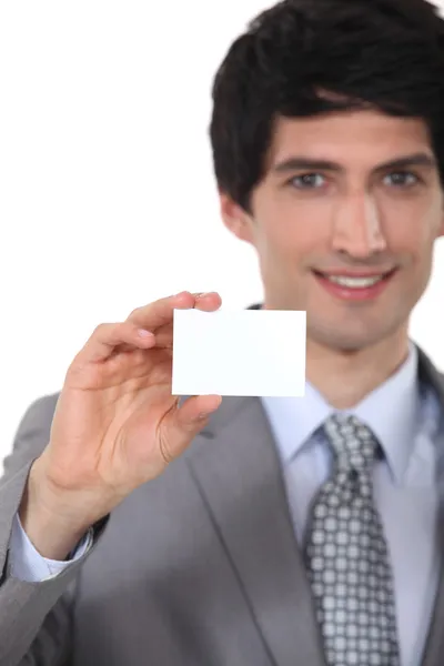 Businessman holding up a blank business card — Stock Photo, Image