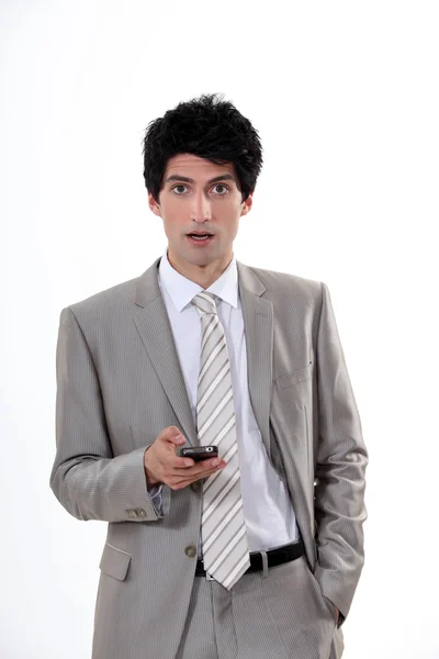 Businessman in shock at his cellphone — Stock Photo, Image
