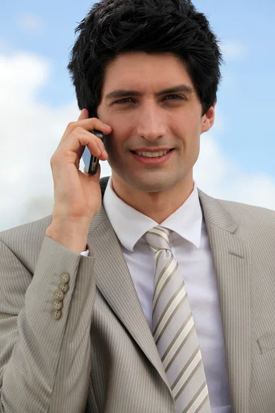 Empresário fazendo uma chamada ao ar livre — Fotografia de Stock