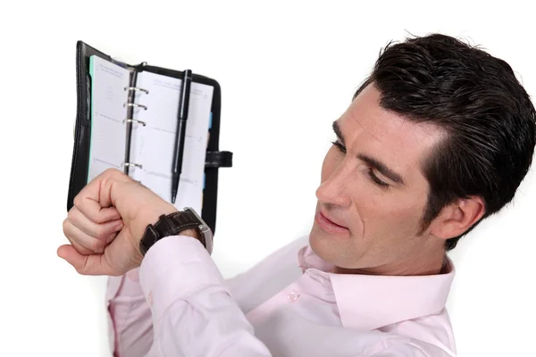 Homme d'affaires regardant son agenda et sa montre — Photo