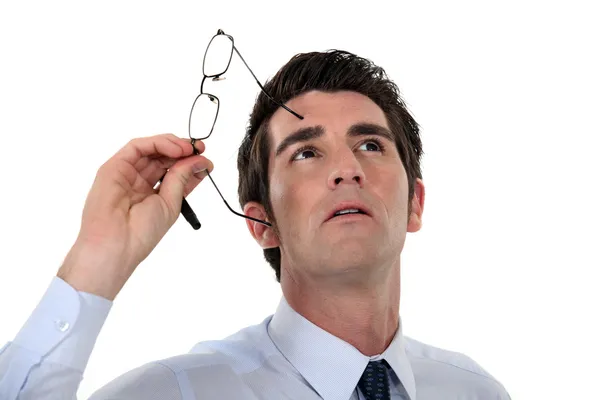 Homem tirando os óculos e olhando para cima — Fotografia de Stock