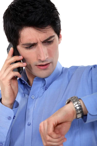 Young entrepreneur on the phone checking watch — Stock Photo, Image