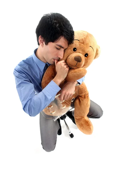 Geschäftsmann umarmt Teddybär und lutscht Daumen — Stockfoto