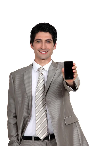 Ein Geschäftsmann reicht sein Handy. — Stockfoto
