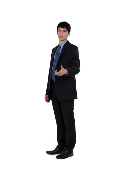 Handsome businessman shaking hands with someone — Stock Photo, Image